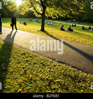 A man carrying a briefcase walks in the autumn sunshine in St. James park london England UK Stock Photo