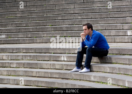 Young man sitting on steps outdoors Stock Photo