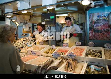 SPAIN Salamanca Man and woman prepare fish and seafood for customers at indoor market seafood and fish displayed Stock Photo