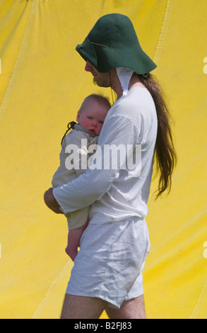 Man in costume with baby in arms at Tewkesbury Medieval Festival Worcestershire UK EU Stock Photo