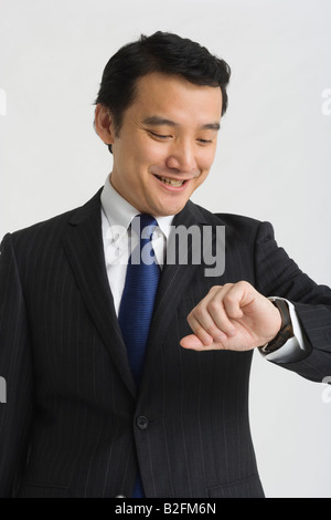 Close-up of a businessman checking the time and smiling Stock Photo