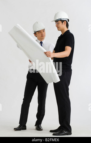 Two male architects discussing on a blueprint Stock Photo