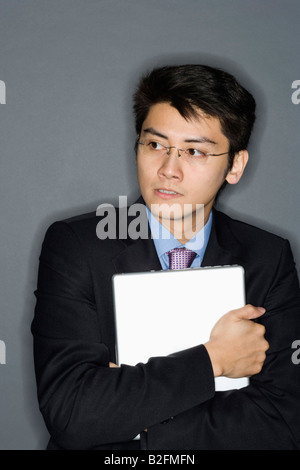 Close-up of a businessman hugging a laptop Stock Photo