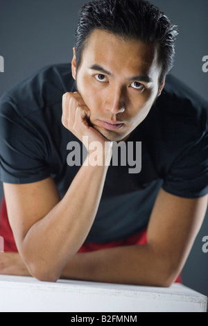 Portrait of a young man leaning on elbows Stock Photo