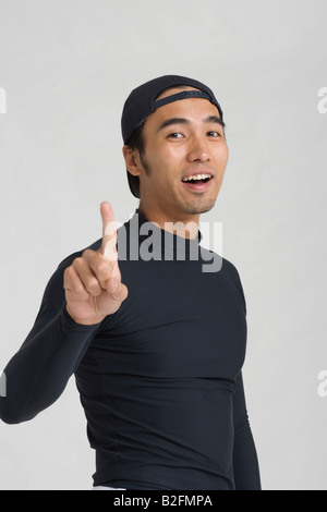 Portrait of a young man pointing and smiling Stock Photo
