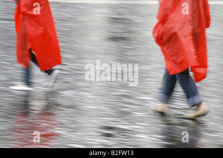 couple wearing waterproof coat capes in rain Stock Photo