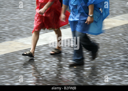 couple wearing waterproof coat capes in rain Stock Photo