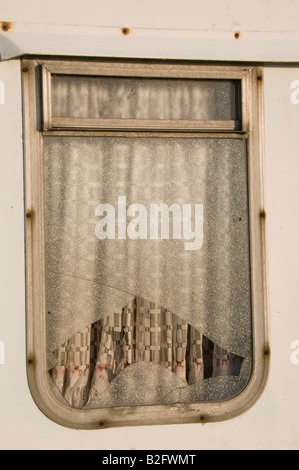 Broken window on a disused caravan Stock Photo