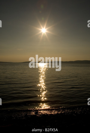 The sun sets over the rock pools of Morecambe Bay at Silverdale, Lancashire, England Stock Photo
