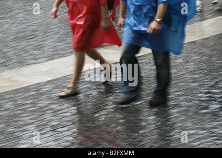 couple wearing waterproof coat capes in rain Stock Photo