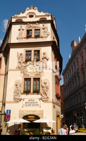 The façade of the Hotel U Zlate Studny decorated with statues and flowers. Stock Photo