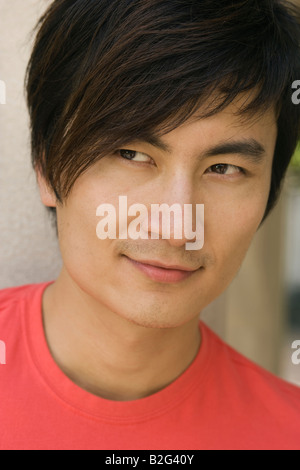 Close-up of a young man smiling and looking sideways Stock Photo