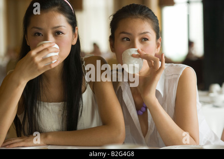 Two young women having tea in a restaurant Stock Photo