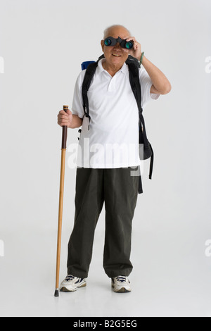 Senior man looking through a pair of binoculars Stock Photo