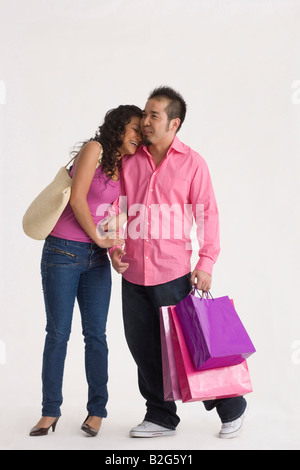 Young woman with a young man holding shopping bags and smiling Stock Photo