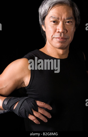 Mature man leaning against a rope in a boxing ring Stock Photo