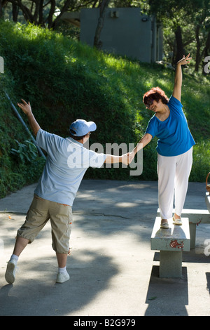 Rear view of a senior man with a mature woman dancing in a park Stock Photo