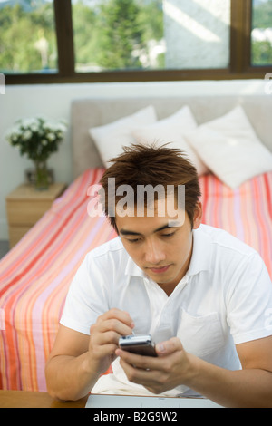 Young man operating a personal data assistant Stock Photo