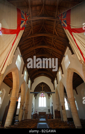 White Ensign flags from HMS Nelson hanging inside All Saints Church at Burnham Thorpe, Norfolk. Stock Photo
