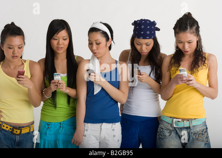 Five young women text messaging Stock Photo