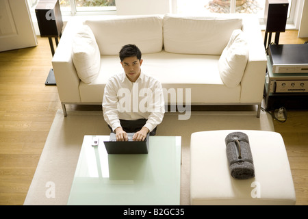 Portrait of a young man using a mobile phone and laptop Stock Photo