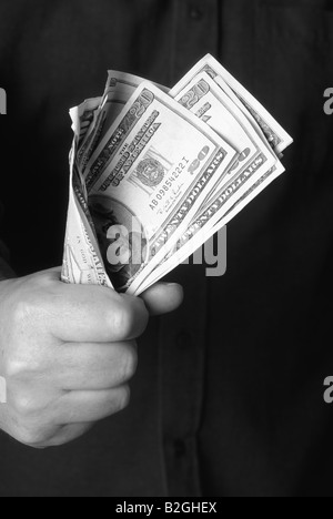 Close up concept grey scale banknote money image Fistful of Dollars mans clenched hand holding wad of dollar bills bank notes Stock Photo