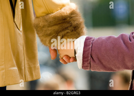 child and her mom mother take each other hands Stock Photo