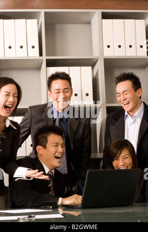 Five business executives using a laptop in an office Stock Photo