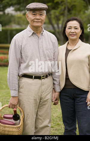 Portrait of a senior couple standing in a park Stock Photo