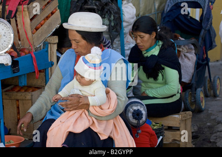 Ecuadorian mother Young child sitting on mother's lap, wearing white hat. Otavalo 70364 Ecuador Otavalo Stock Photo