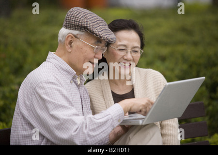 Senior couple using a laptop and smiling Stock Photo