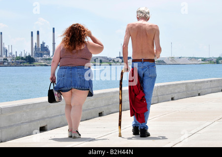 Fat overweight woman walking with skinny thin man Stock Photo