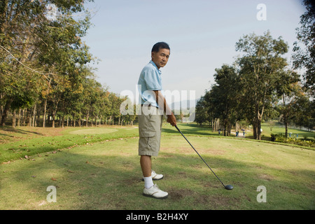 Side profile of a mature man playing golf Stock Photo