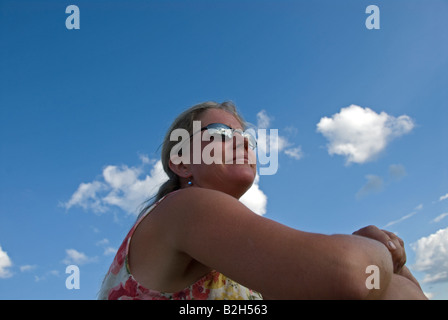 Stock photo of a woman wearing sunglasses looking into the distance Stock Photo