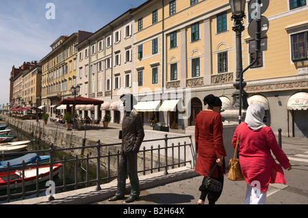 Two muslim women walk past the statue of the Irish writer James Joyce Trieste Italy Europe Stock Photo