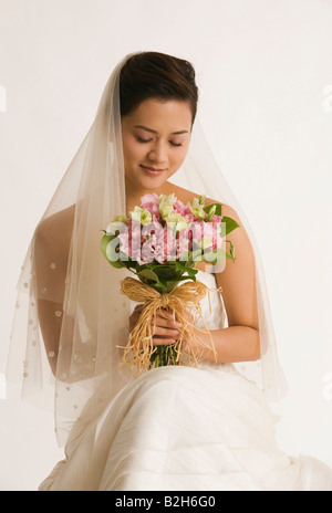Bride sitting down with bouquet on her dress in black and white Stock ...