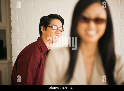 Close-up of a young woman smiling with a young man smiling behind her Stock Photo