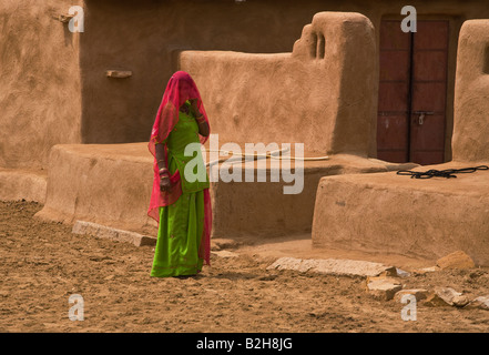 A BANJARI TRIBAL WOMAN and her classic MUD HOUSE in a village in the THAR DESERT near JAISALMER RAJASTHAN INDIA Stock Photo