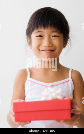 Portrait of a girl holding a gift box and smiling Stock Photo