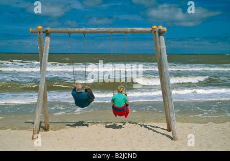 pensioners old people couple swing set beach Spiekeroog  East Frisian Islands Germany Stock Photo