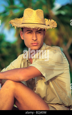 Maldives. Side view, close-up of a young man wearing straw hat, sitting. Stock Photo