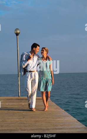 Maldives. Front view of a young couple walking on jetty. Stock Photo