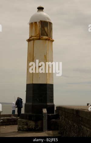 Grandfather & grandson fishing by Porthcawl lighthouse at the end of the breakwater Porthcawl Harbour, S Wales UK GB Stock Photo