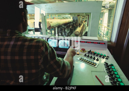 Man operating computerized control room at saw mill. Stock Photo