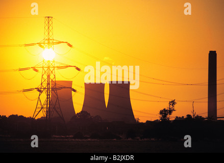 United Kingdom. England, Berkshire. Silhouette of Didcot power station cooling towers and electricity pylon with evening sun. Stock Photo