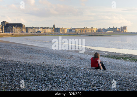 Young woman alone on Morecambe beach Stock Photo