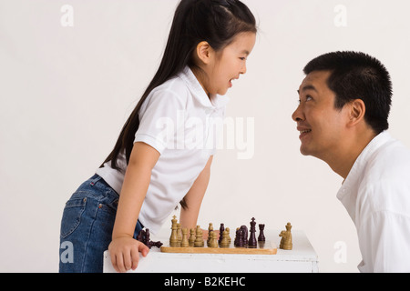 Side profile of a mid adult man looking at his daughter smiling Stock Photo