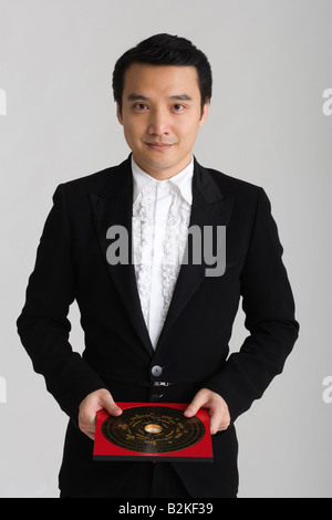 Portrait of a male fortune teller holding a Chinese feng shui compass Stock Photo