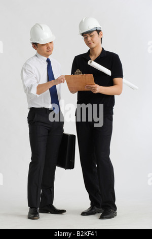 Two male architects discussing on a clipboard Stock Photo