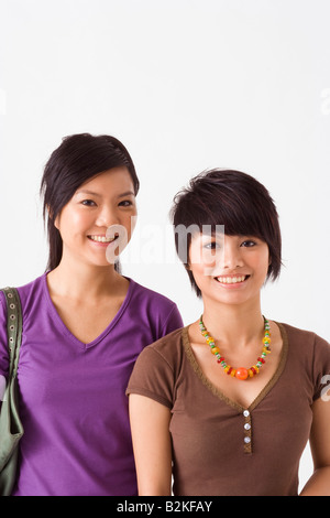 Two young women standing together and smiling Stock Photo